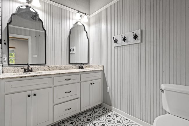Full bathroom with double vanity, toilet, a sink, and tile patterned floors | Image 21