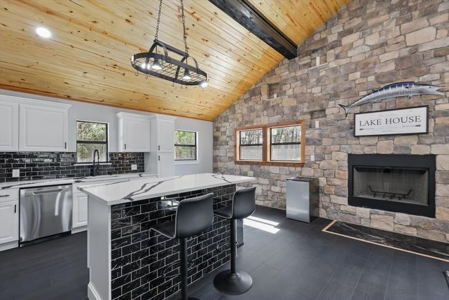 Kitchen with light countertops, lofted ceiling with beams, dark wood-type flooring, wood ceiling, and dishwasher | Image 21
