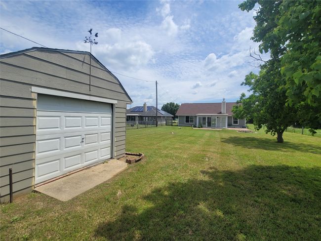 View of grassy yard with an outbuilding and a detached garage | Image 27
