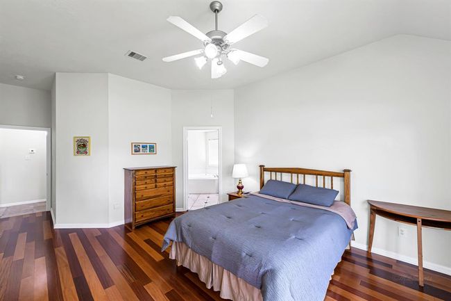 Spacious primary En-suite with beautiful hardwood flooring, high ceilings and ceiling fan | Image 13