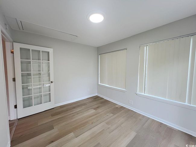 Spare room featuring baseboards, attic access, and wood finished floors | Image 35
