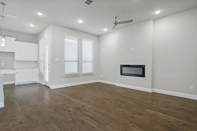 Unfurnished living room with visible vents, baseboards, ceiling fan, recessed lighting, and dark wood-style floors | Image 9