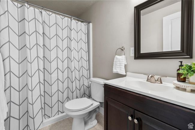 Full bath featuring vanity, toilet, curtained shower, and tile patterned flooring | Image 24