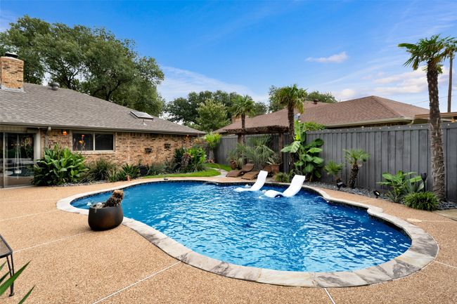 View of swimming pool with a fenced backyard and a patio area | Image 33