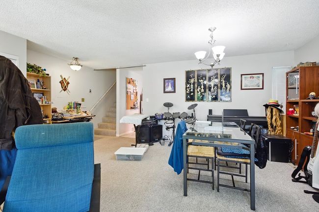 Dining space with carpet, stairway, a textured ceiling, and a chandelier | Image 14