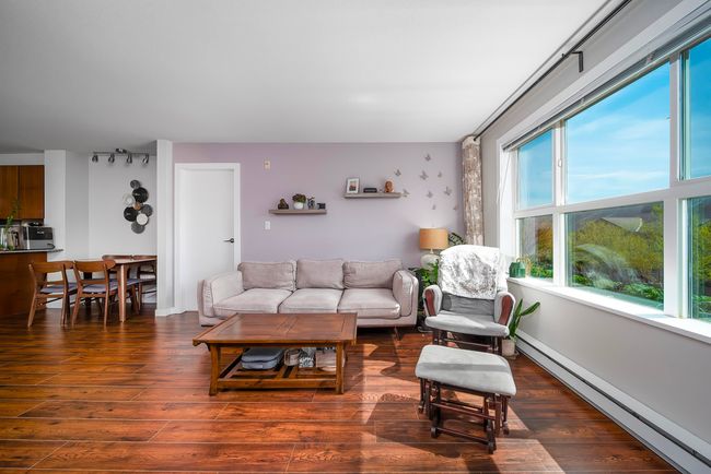 Living area featuring a baseboard heating unit and wood finished floors | Image 13
