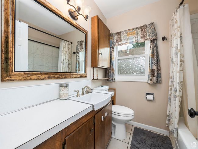 Full bathroom featuring vanity, tile patterned floors, and shower / bath combination with curtain | Image 9