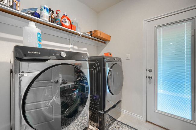 Washroom featuring washing machine and clothes dryer, baseboards, and light tile patterned floors | Image 14
