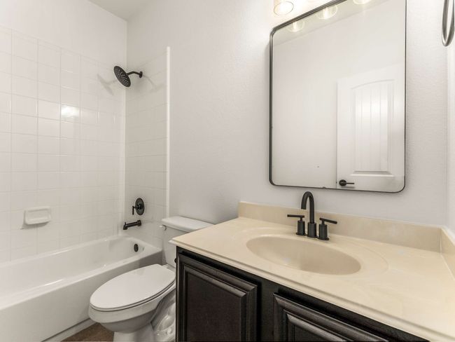 Bathroom featuring vanity and bathtub / shower combination | Image 34