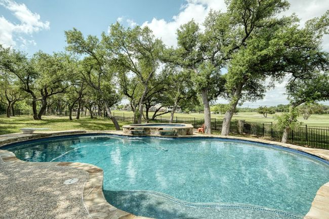 View of pool with a pool with connected hot tub, a lawn, and fence | Image 28