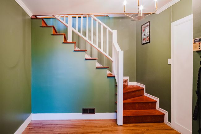 Staircase featuring wood finished floors, visible vents, crown molding, and baseboards | Image 5