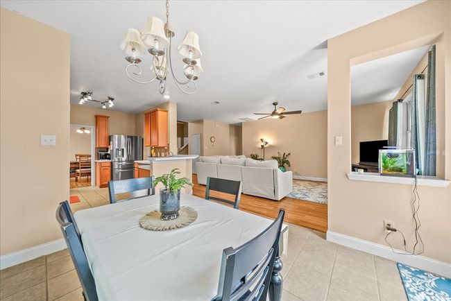Dining area featuring baseboards, light tile patterned flooring, a chandelier, and a ceiling fan | Image 22