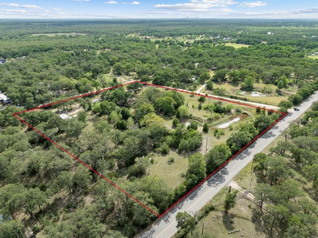 Aerial overview of property's location featuring property boundaries highlighted and a heavily wooded area | Image 4