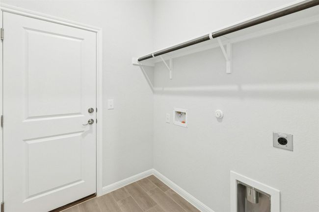 Laundry room with electric dryer hookup, gas dryer hookup, washer hookup, baseboards, and light wood-type flooring | Image 21