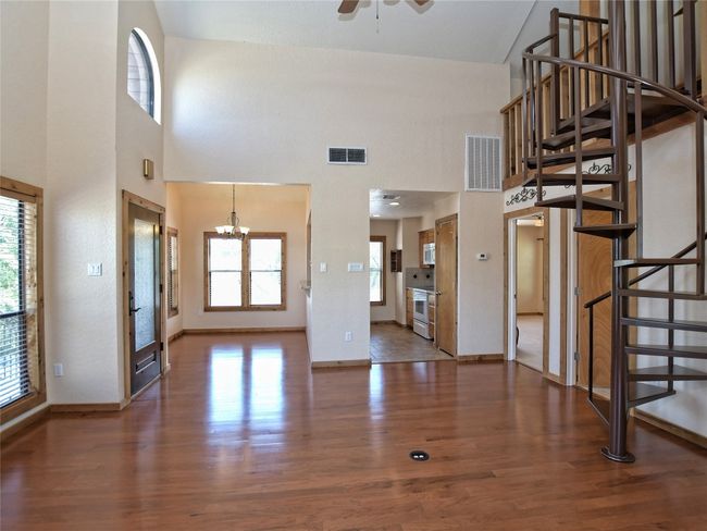 View from Living looking into the Kitchen and toward the Dining Area. Door to the right of the Kitchen entry leads to the main level Primary Suite. | Image 8