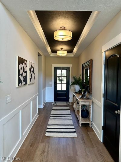 Foyer entrance with dark wood-type flooring, a textured ceiling, and a tray ceiling | Image 2