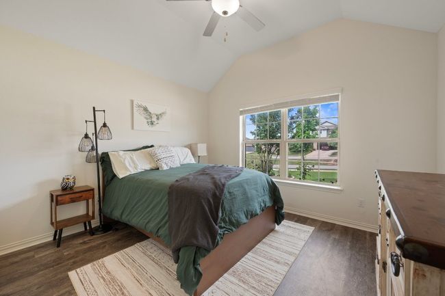 Bedroom featuring vaulted ceiling, dark wood-type flooring, baseboards, and a ceiling fan | Image 18
