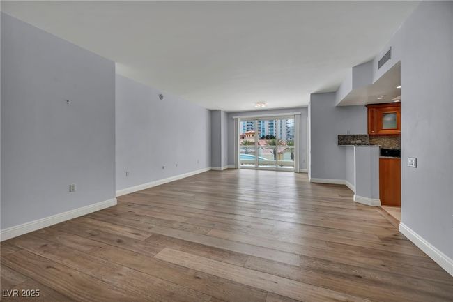 Unfurnished living room featuring hardwood / wood-style floors, visible vents, and baseboards | Image 16