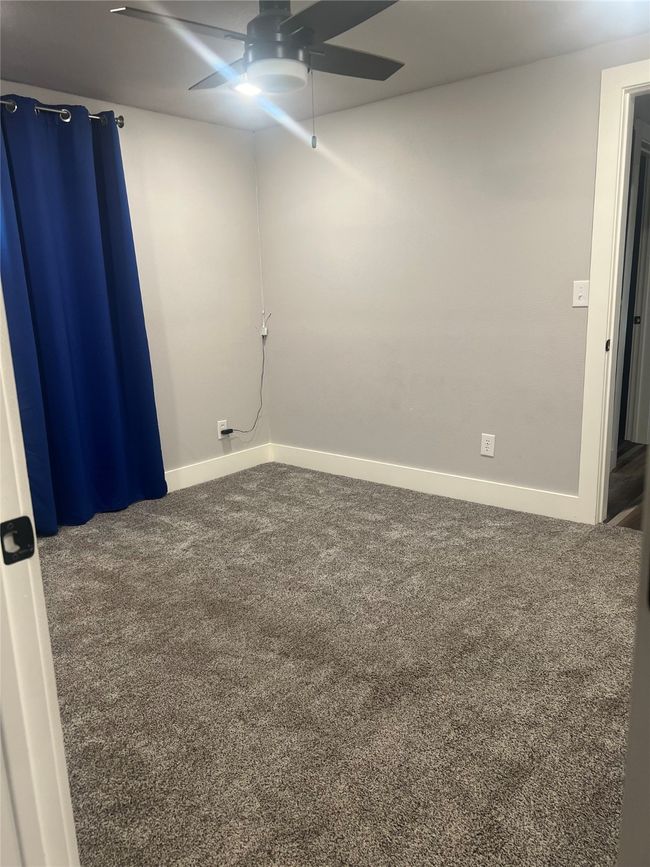 Carpeted empty room featuring ceiling fan and baseboards | Image 5