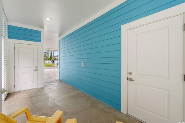 Hallway featuring concrete flooring, wooden walls, and recessed lighting | Image 4