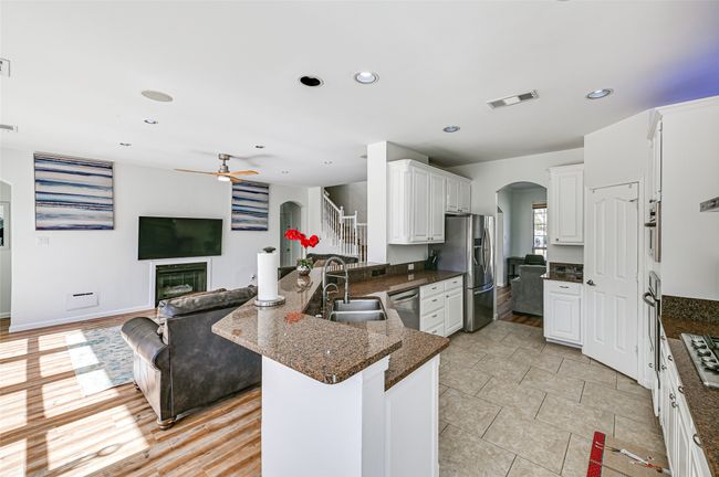 Kitchen with kitchen peninsula, ceiling fan, appliances with stainless steel finishes, sink, and light tile floors | Image 9