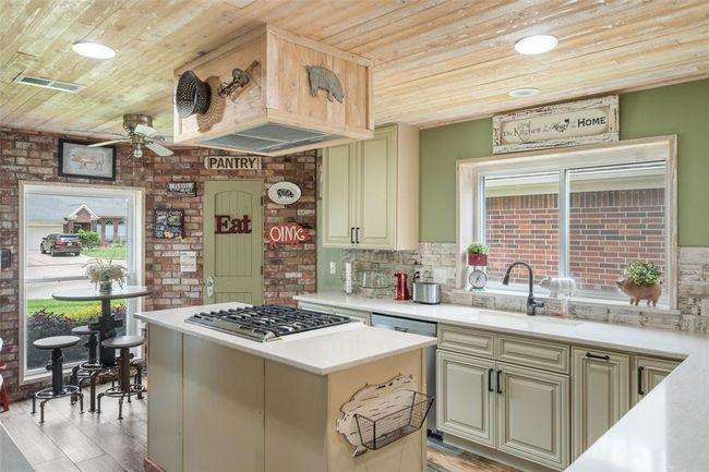 The centerpiece of this culinary paradise is the island cooktop, perfect for creating delicious meals and entertaining guests. | Image 23