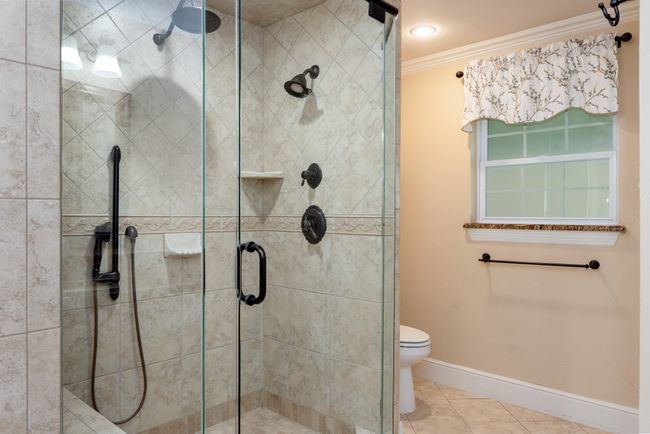 Bathroom featuring ornamental molding, a shower stall, and tile patterned floors | Image 32
