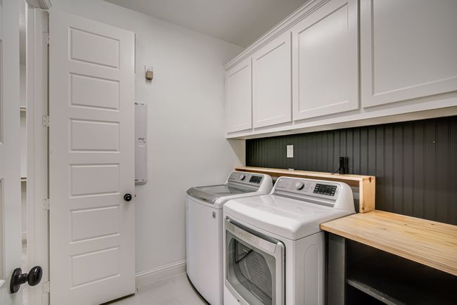 Washroom featuring washer and clothes dryer and cabinets | Image 22