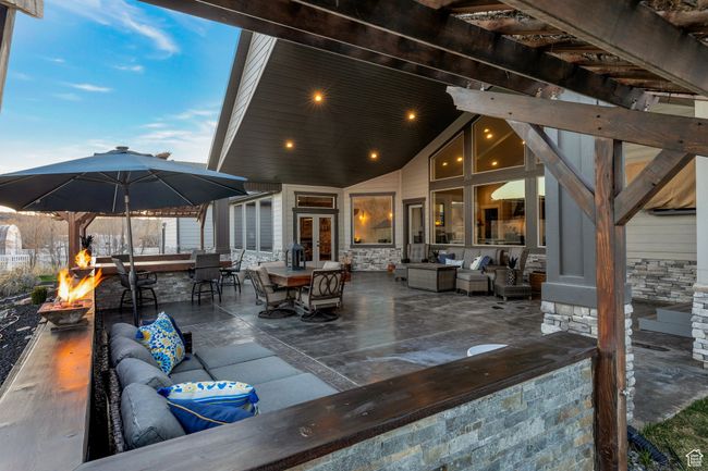 View of patio with an outdoor living space with a fire pit, a pergola, and outdoor dining area | Image 35