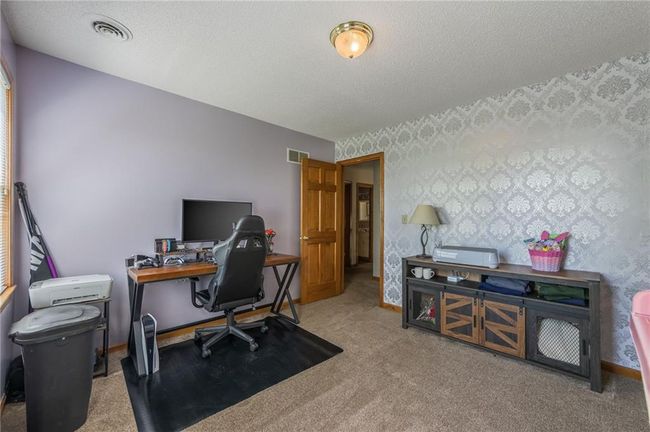 Office space with a textured ceiling, carpet flooring, visible vents, and wallpapered walls | Image 55