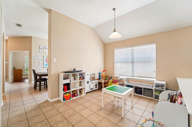 Bright playroom with large window, tiled floors, and ample storage. Opens to dining area and adjacent room. | Image 11