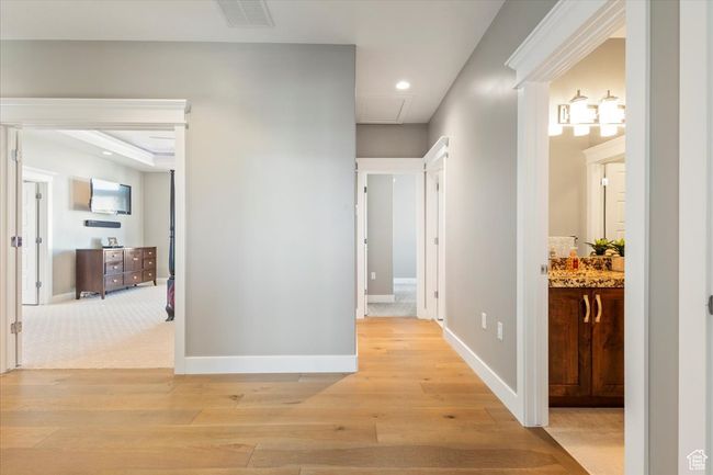Hallway with light wood-style floors, attic access, baseboards, and recessed lighting | Image 25