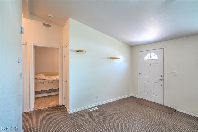 Carpeted foyer featuring vaulted ceiling and baseboards | Image 8