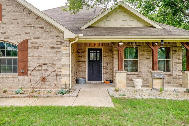Entrance to property with roof with shingles, brick siding, and a porch | Image 6
