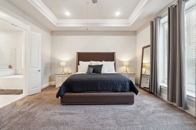 Carpeted bedroom with a raised ceiling, crown molding, and ceiling fan | Image 18