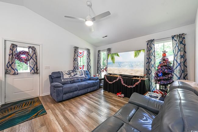 Living area featuring lofted ceiling, wood finished floors, and ceiling fan | Image 5