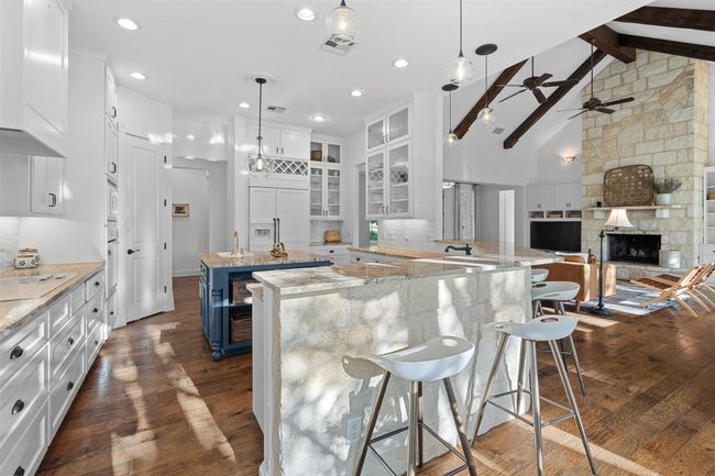Kitchen featuring dark wood-type flooring, paneled built in fridge, white cabinets | Image 11