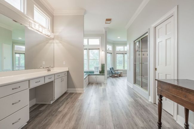 Bathroom featuring vanity, wood floors, crown molding, healthy amount of natural light, and baseboards | Image 23