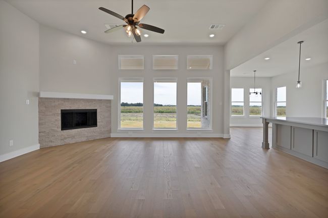 Unfurnished living room with light wood-style floors, a fireplace, recessed lighting, and ceiling fan | Image 9