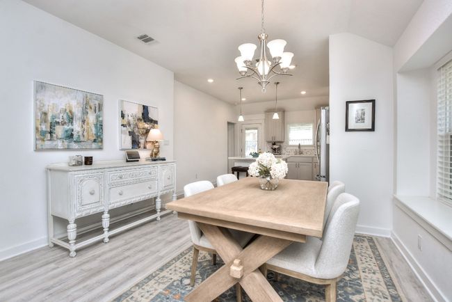 Dining area featuring light wood-style flooring, baseboards, a notable chandelier, and visible vents | Image 5