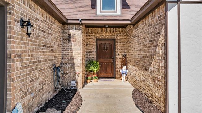 Entrance to property with brick siding and roof with shingles | Image 6