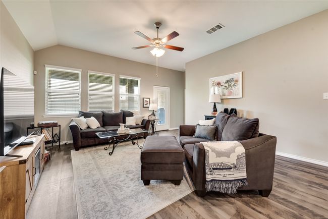 Living room featuring wood finished floors, ceiling fan, and lofted ceiling | Image 15