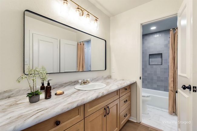 Bathroom featuring vanity and shower / bathtub combination with curtain | Image 19