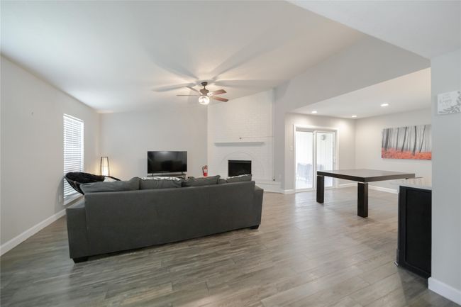 Living room featuring a ceiling fan, wood finished floors, a fireplace, and recessed lighting | Image 6