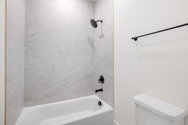 secondary bathroom features tile to the ceiling | Image 25