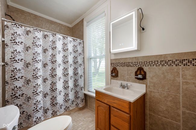full bathroom with vanity, tile walls, crown molding, and tile patterned floors | Image 16