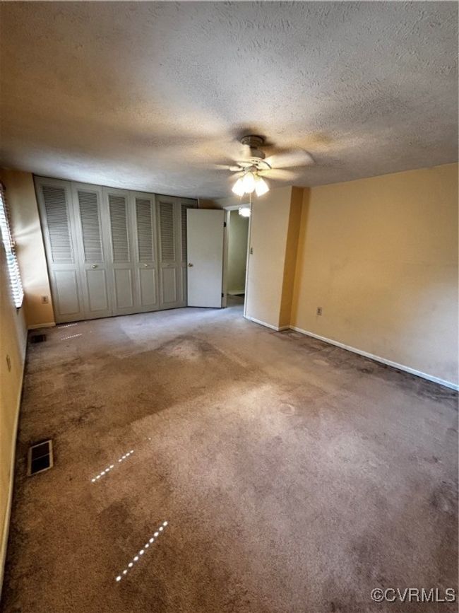 Unfurnished bedroom featuring a textured ceiling, light colored carpet, and a ceiling fan | Image 10