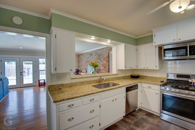 Kitchen with crown molding, appliances with stainless steel finishes, a sink, and french doors | Image 12