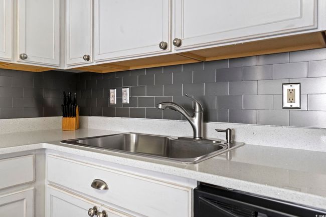Kitchen with black dishwasher, tasteful backsplash, a sink, and white cabinets | Image 15