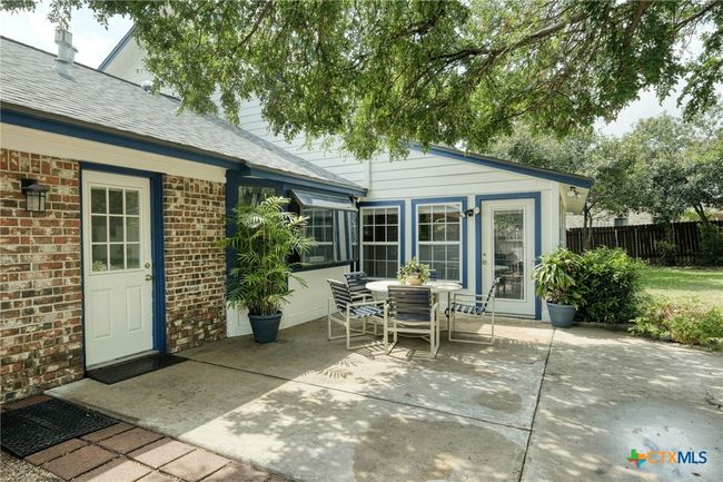 Open Patio with the door on the left leading into the laundry room. The door behind the table leads into the oversized sunroom for extended entertaining. | Image 27